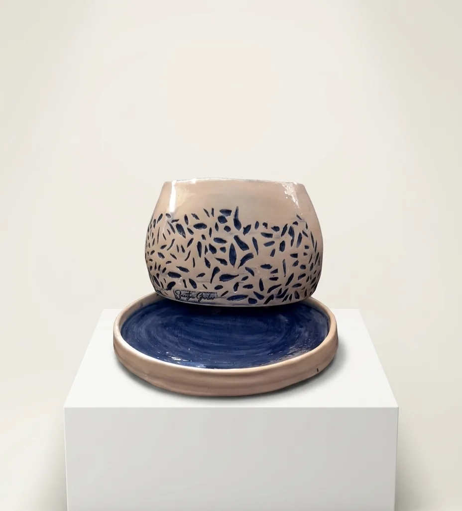 Indigo Speckle Bowl — a blush bowl flecked with indigo brushstrokes, resting on a matching indigo-glazed plate.