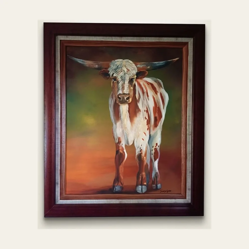 Nguni Bull II — a long-horned Nguni bull standing against a green and rust ground, in a dark timber frame.