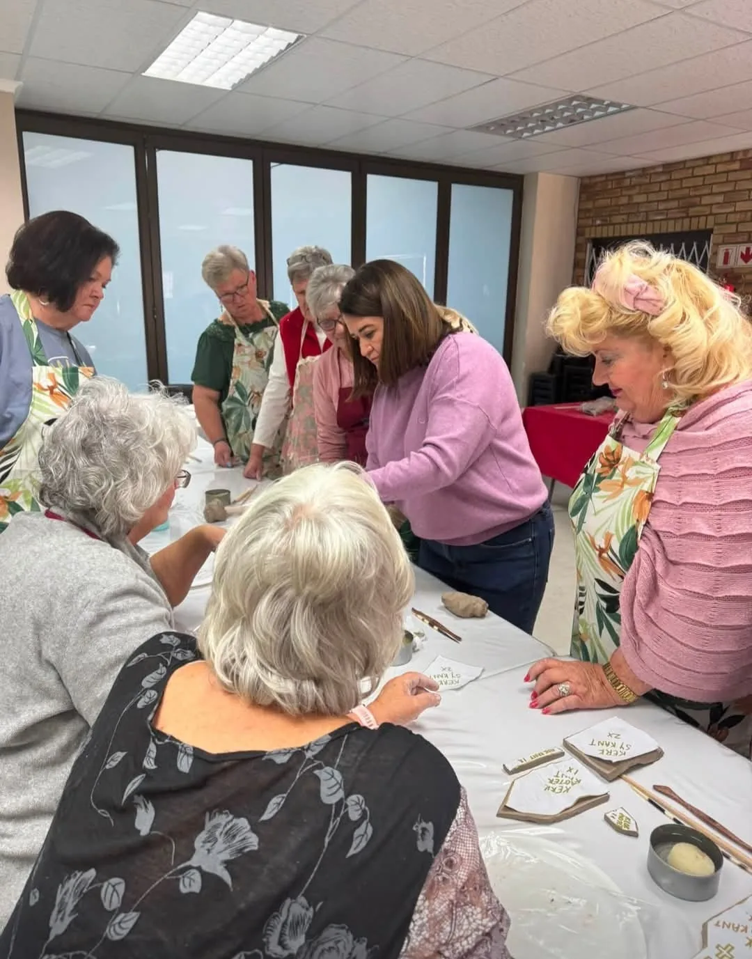 Vroue rondom die tafel besig om met klei te werk tydens 'n PPK Kerk werkswinkel.